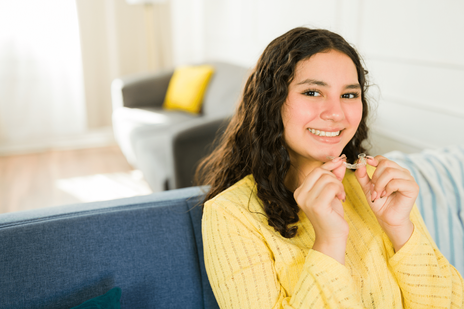 Teen holding Invisalign aligners for severe crowding treatment in San Antonio TX